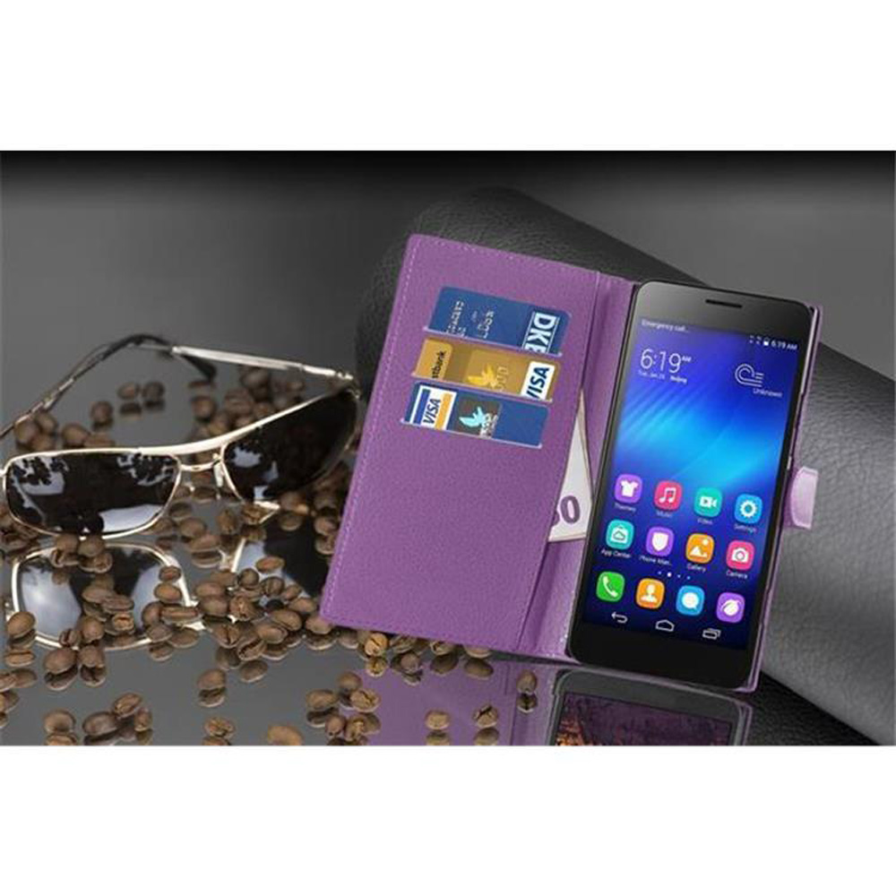 Lila Handyhülle mit Kartenfächern und einem Telefon, Sonnenbrille und Kaffeebohnen auf spiegelnder Oberfläche.