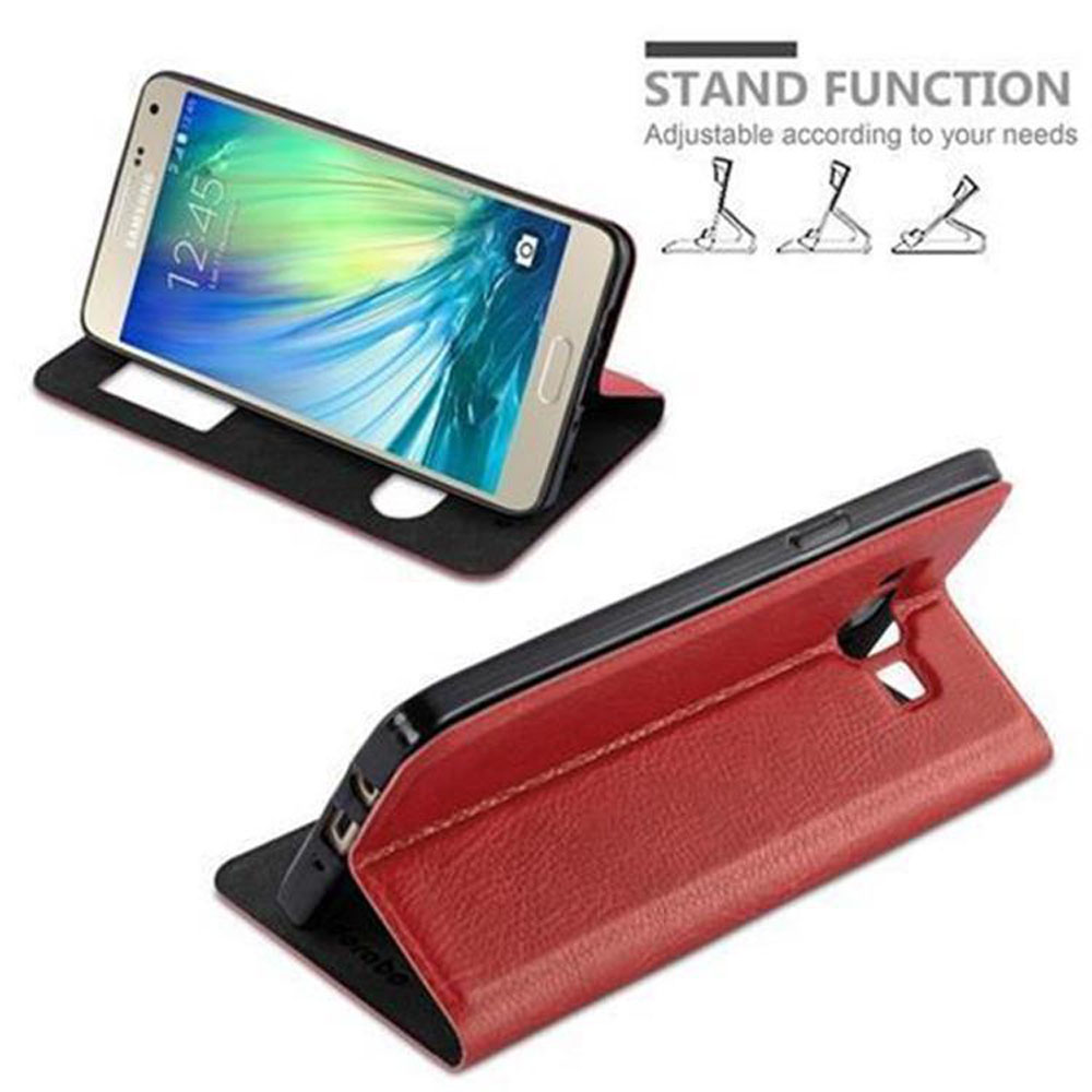 Un telefono è in una custodia rossa. È configurato per stare in piedi. Un altro telefono è sopra.