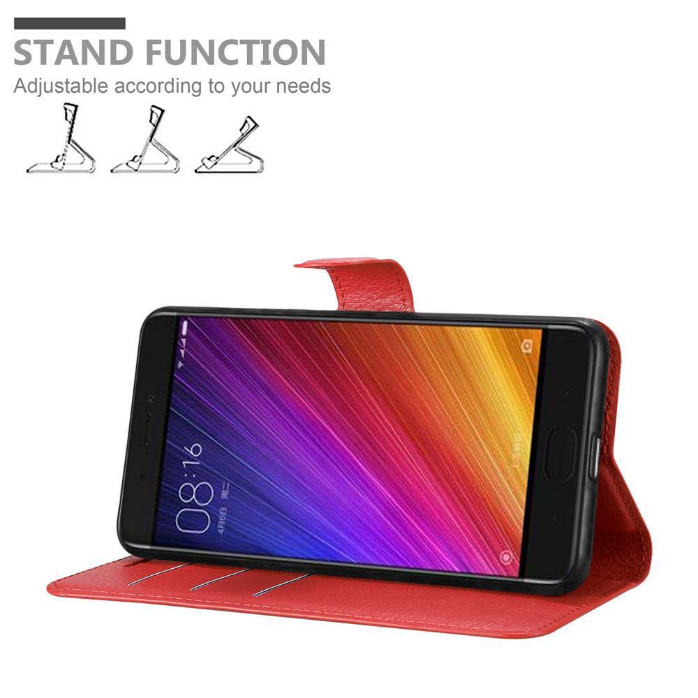 Telefono in custodia rossa, su supporto. Testo: Funzione supporto. Il telefono ha uno schermo arcobaleno. Custodia rossa.