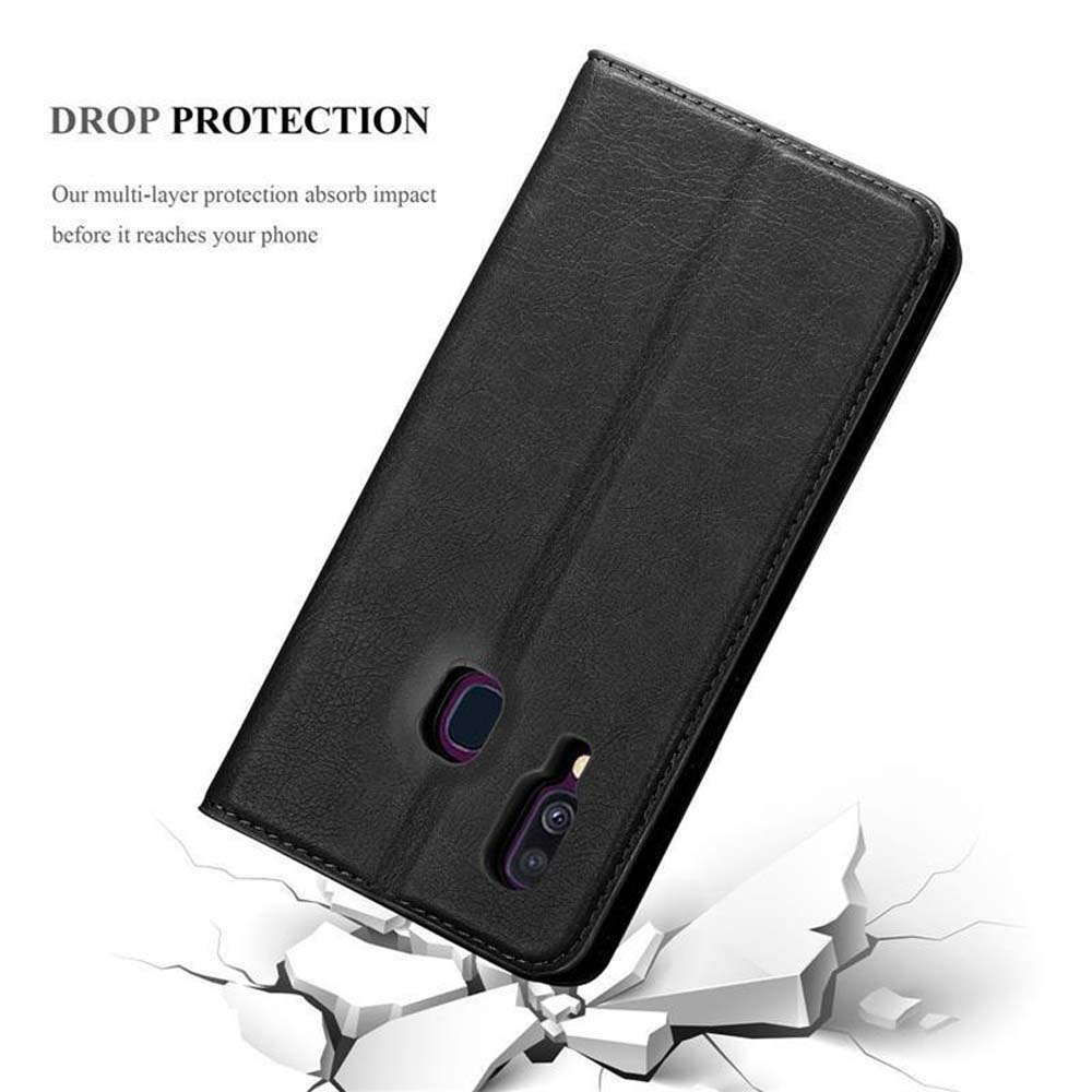 Una funda negra de teléfono cayendo y rompiendo una superficie blanca.