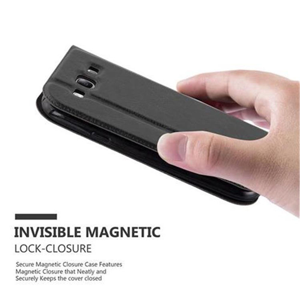 Mano sosteniendo una funda negra para teléfono. La funda está cerrada y tiene un diseño de cierre magnético.