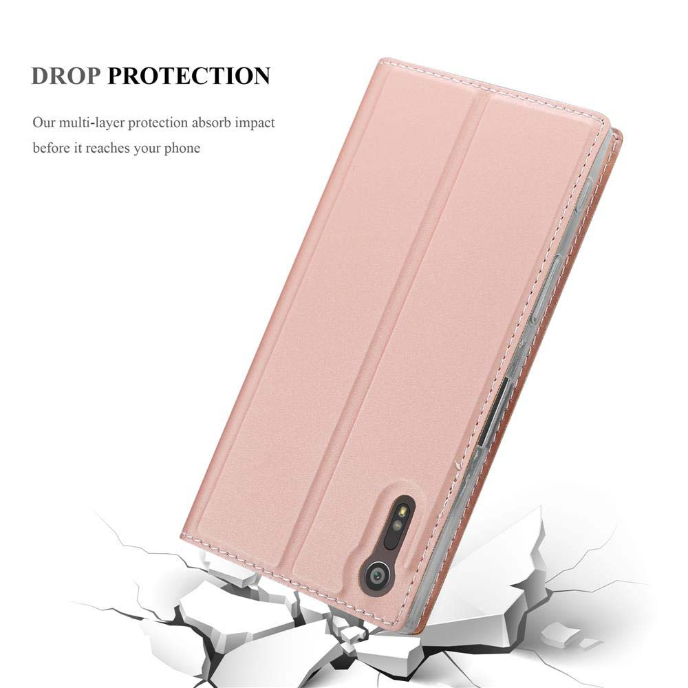 Una custodia per telefono rosa chiaro con un telefono all'interno. La custodia è aperta e su una superficie rotta.