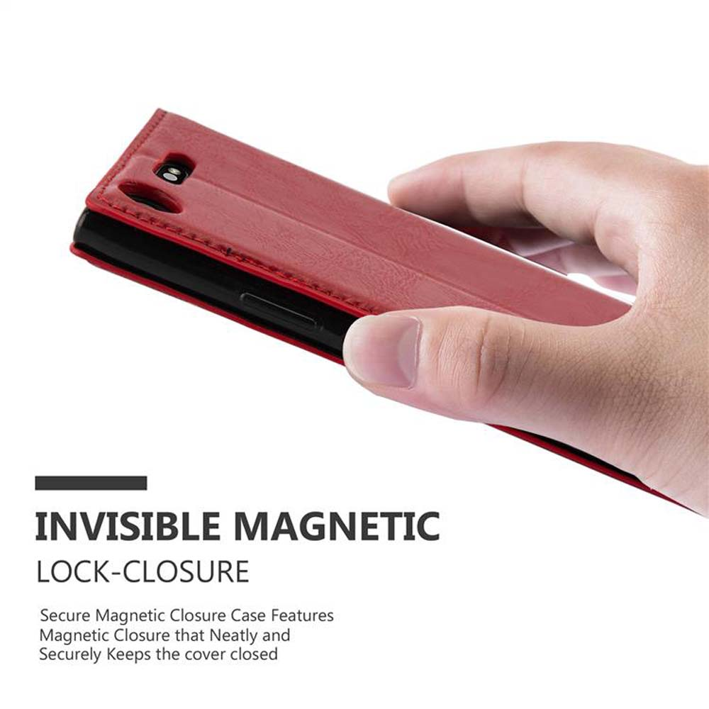 Una mano che tiene una custodia rossa con un telefono all'interno. Chiusura magnetica invisibile.
