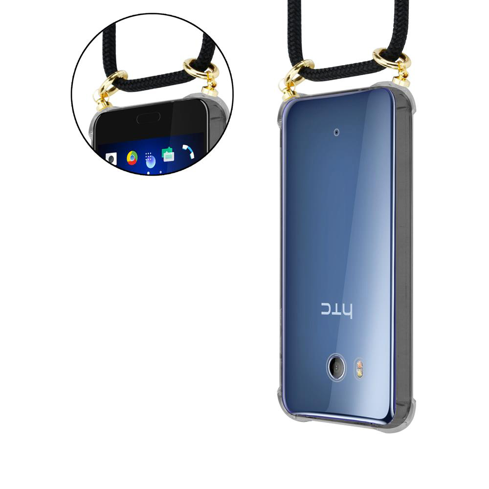 Telefon mit durchsichtiger Hülle und schwarzem Kordelband mit goldenen Akzenten. Nahaufnahme des Telefons und der Hülle.