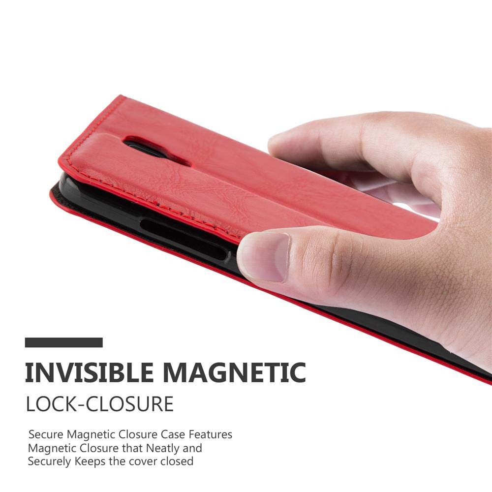 Una mano abre una funda roja para teléfono, revelando un teléfono negro. La funda tiene cierre magnético.