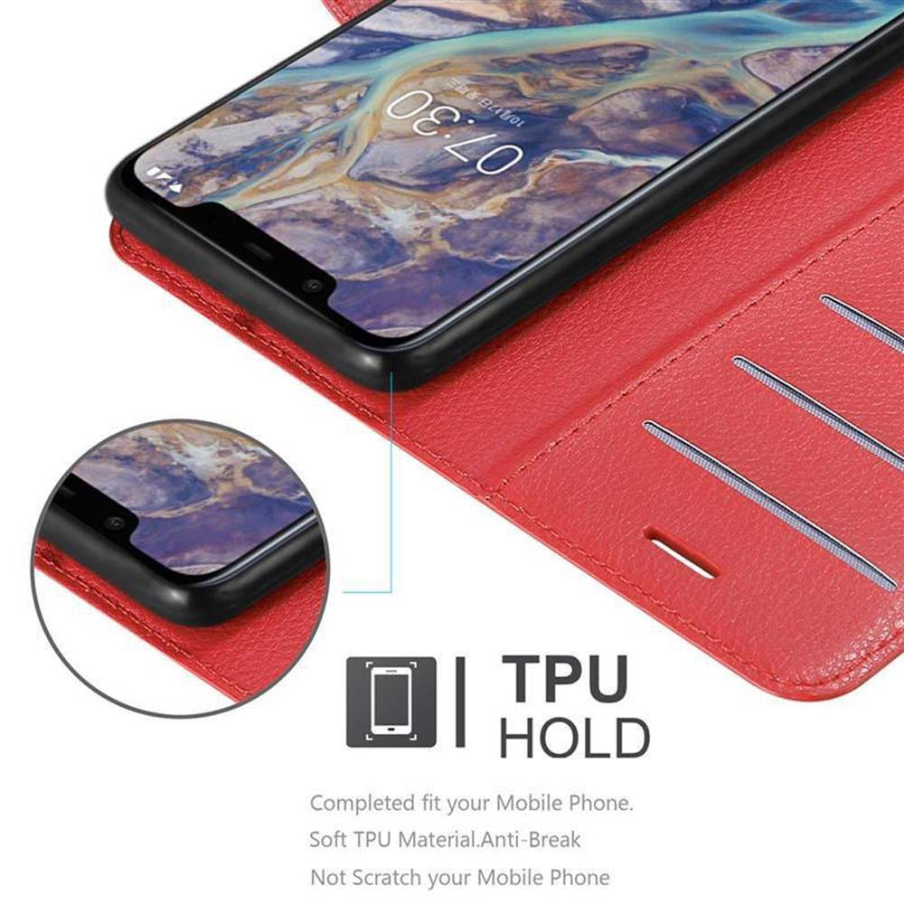 Uno smartphone nero in una custodia rossa. La custodia è aperta, rivelando fessure per carte.