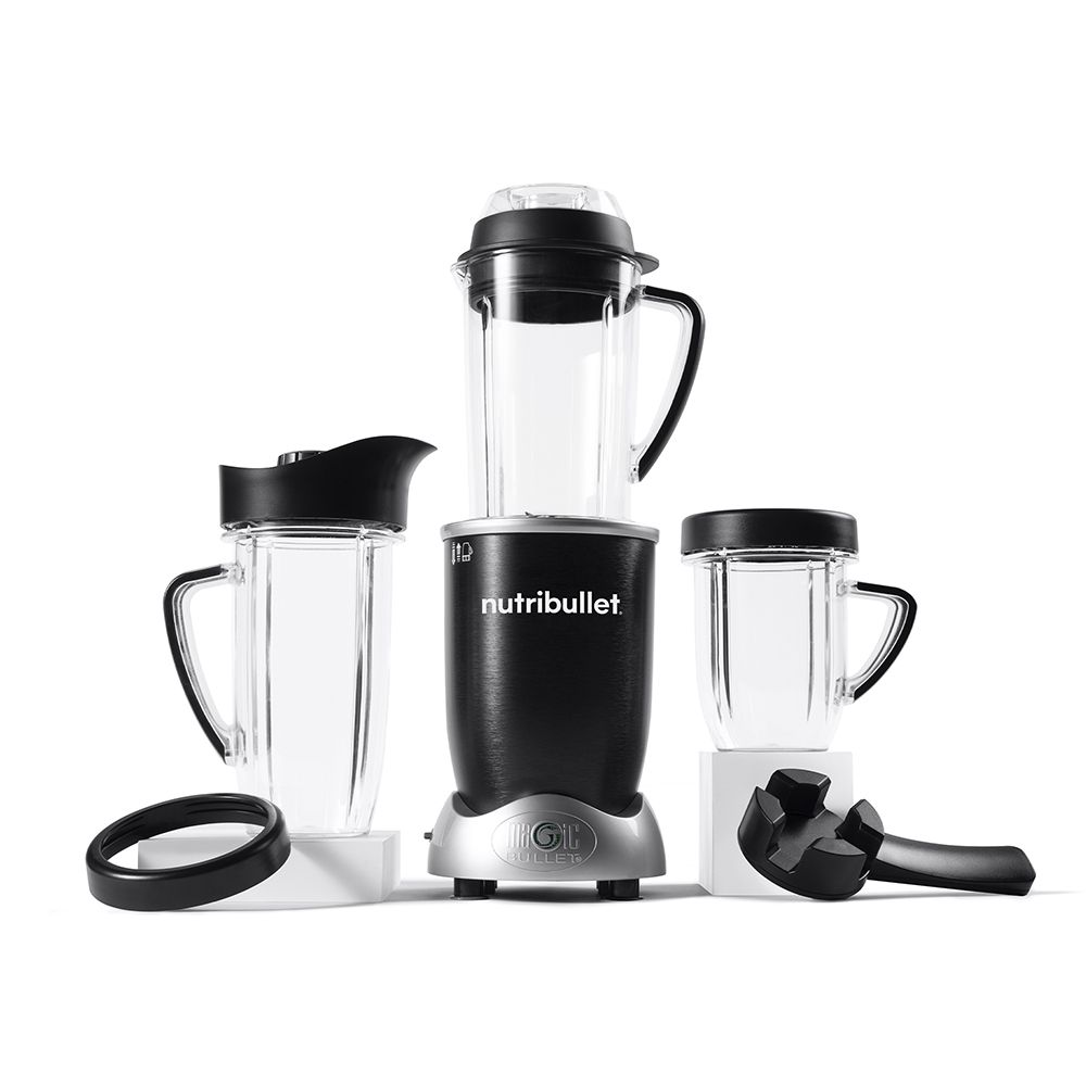 Un blender Nutribullet noir et argenté avec plusieurs tasses et accessoires sur une surface blanche.