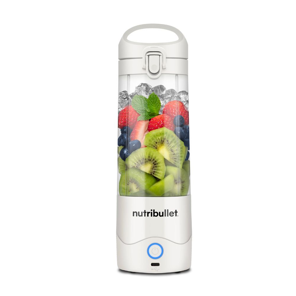 Un blender Nutribullet blanc rempli de glace, de fruits et de menthe, avec un bouton d'alimentation bleu.