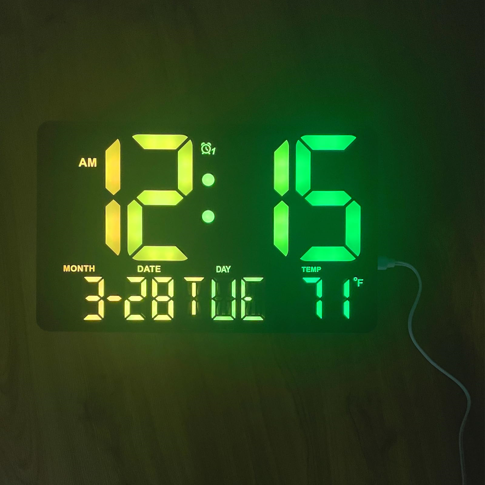 Digitaluhr zeigt 12:15 Uhr morgens, Datum, Tag und 71°F an. Schwarzer rechteckiger Rahmen, grüne und gelbe Zahlen.