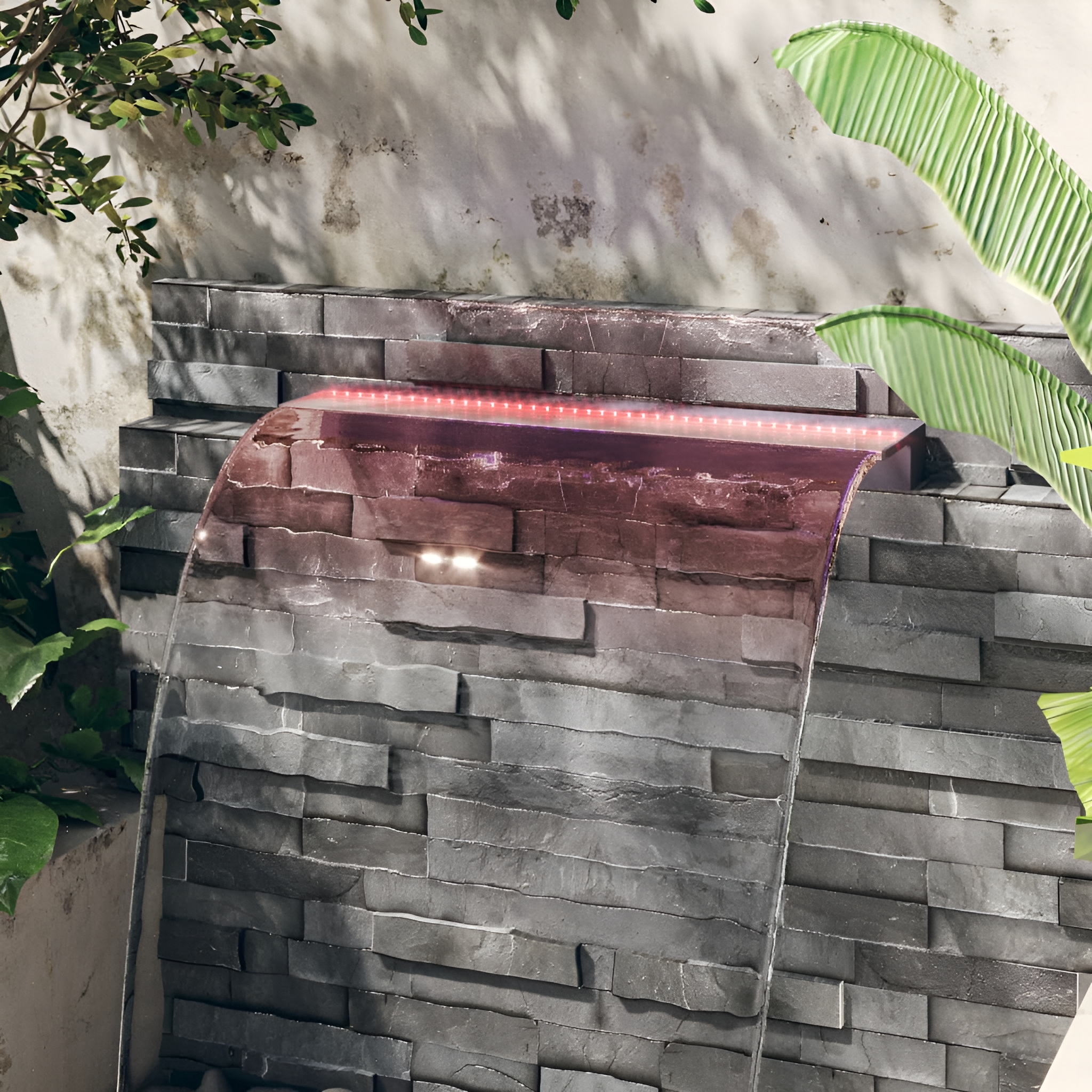 Ein Wasserspiel mit Wasserfall und Steinmauer. Rote Lichter beleuchten das Wasser.