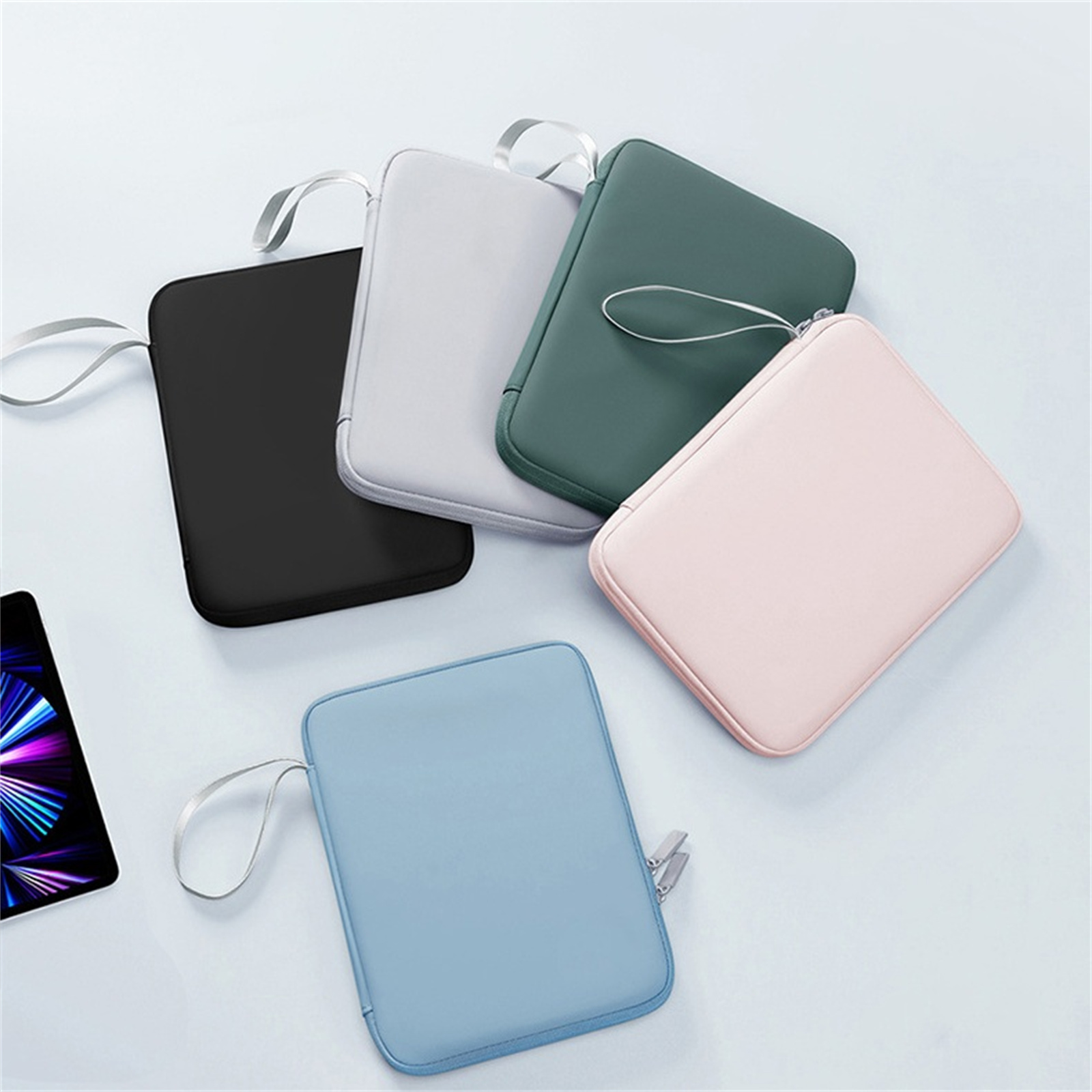 Mehrere bunte Tablet-Hüllen, jeweils mit einer kleinen Schlaufe zum Tragen.