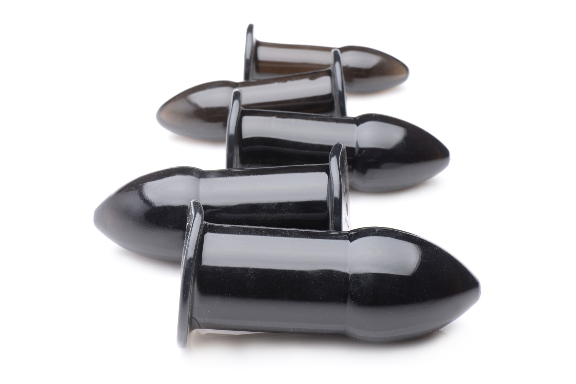 Fünf schwarze Silikon-Buttplugs in einer Reihe auf weißem Untergrund. Jeder hat einen ausgestellten Sockel.