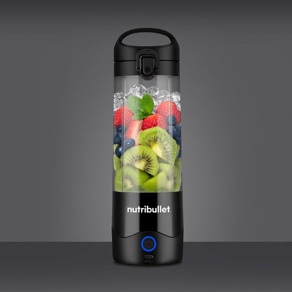 Zwarte Nutribullet-blender gevuld met fruit en ijs, donkere achtergrond.