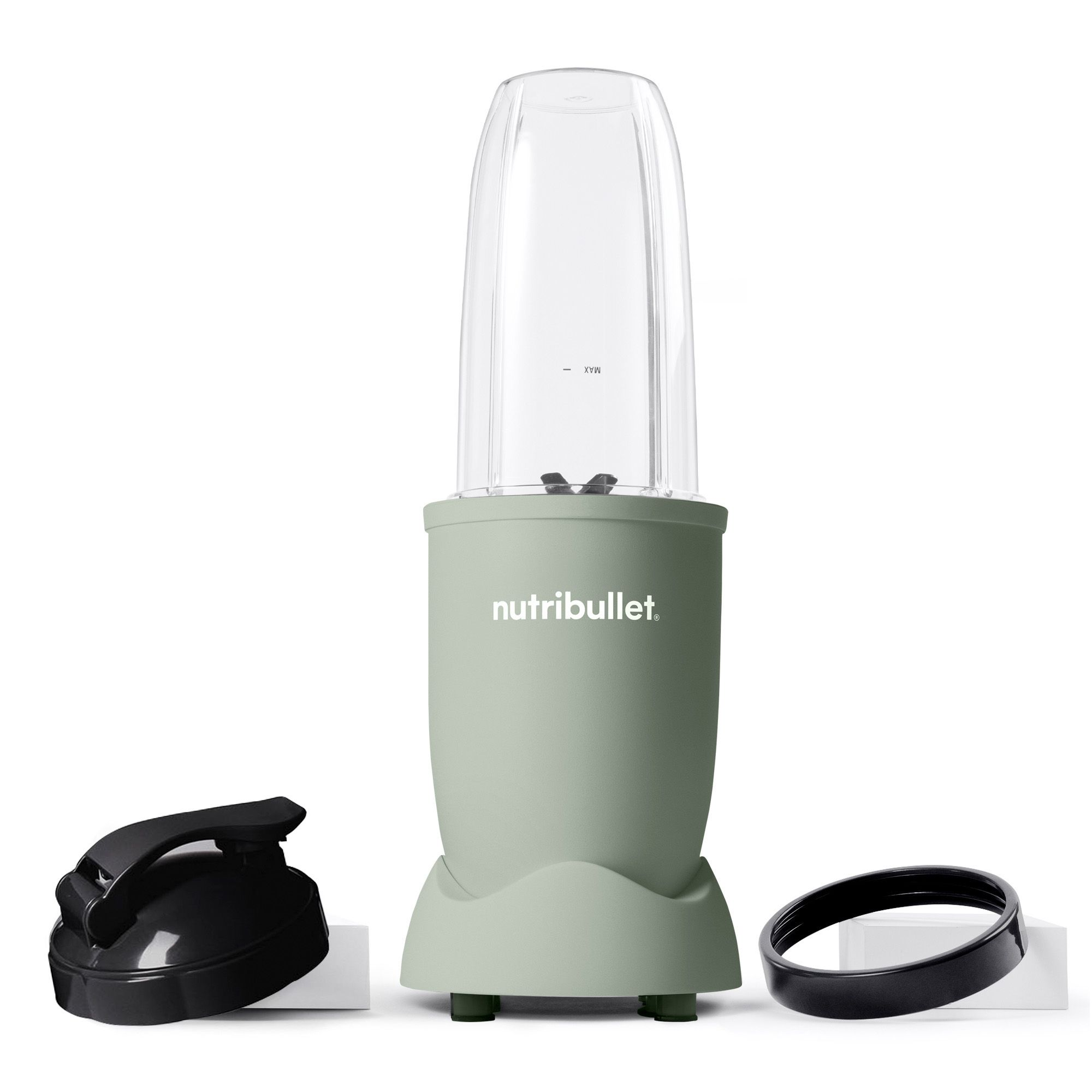 A green nutribullet blender with accessories on a white surface.