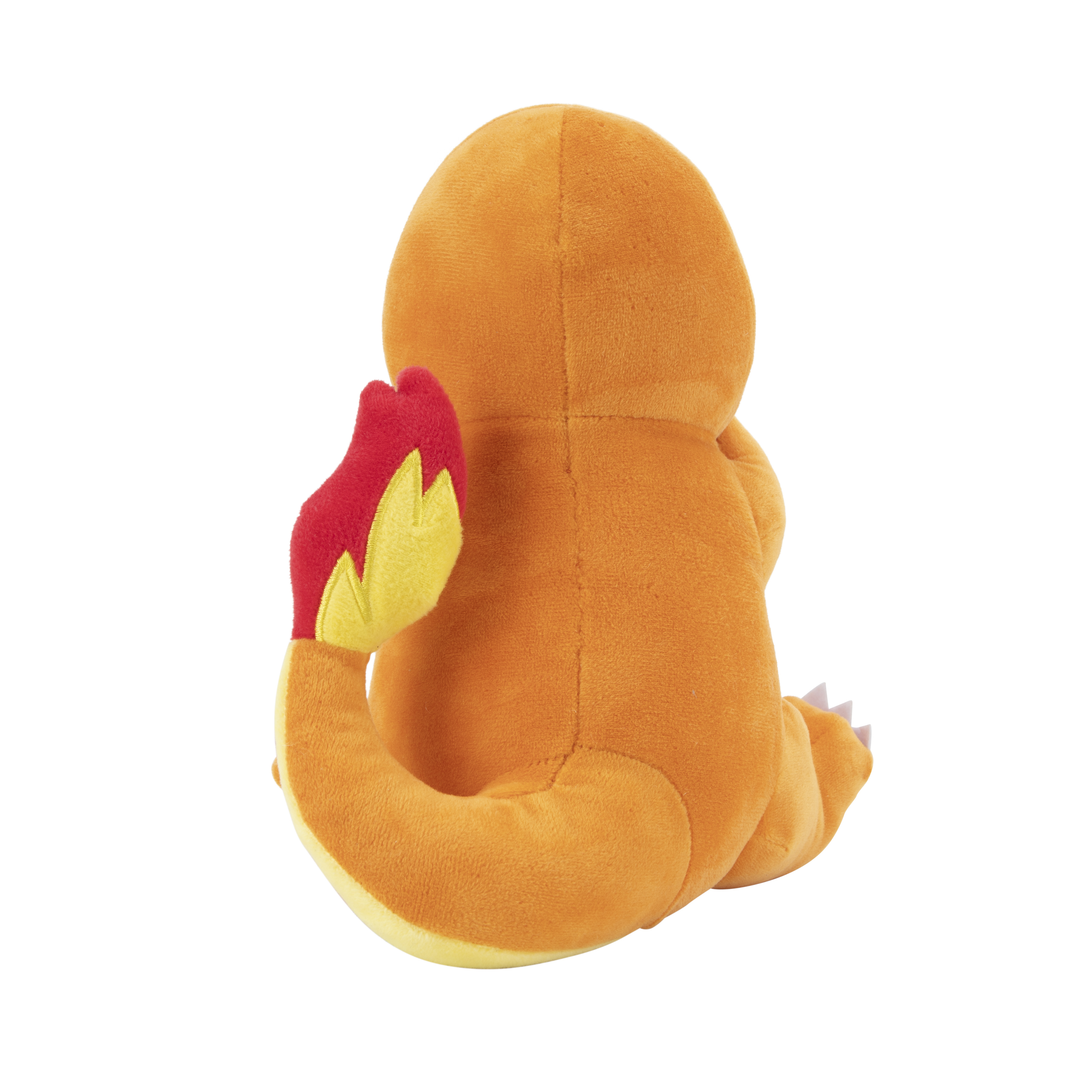 Ein Stofftier-Charmander. Das Spielzeug ist orange mit Flammschwanz und gelbem Bauch. Weißer Hintergrund.