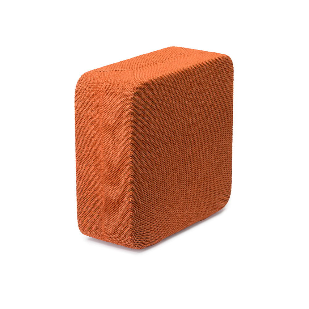 Bloc rectangulaire orange, peut-être un bloc de yoga, sur fond blanc. Le bloc est légèrement incliné.