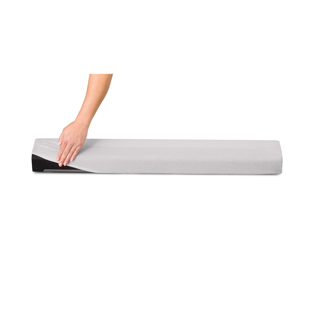 Une main plaçant un couvercle blanc sur une barre de son noire sur fond blanc.