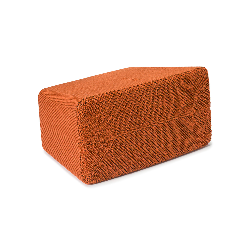 Ein orangefarbener rechteckiger Block. Es hat eine gewebte Textur und ist auf weißem Hintergrund.