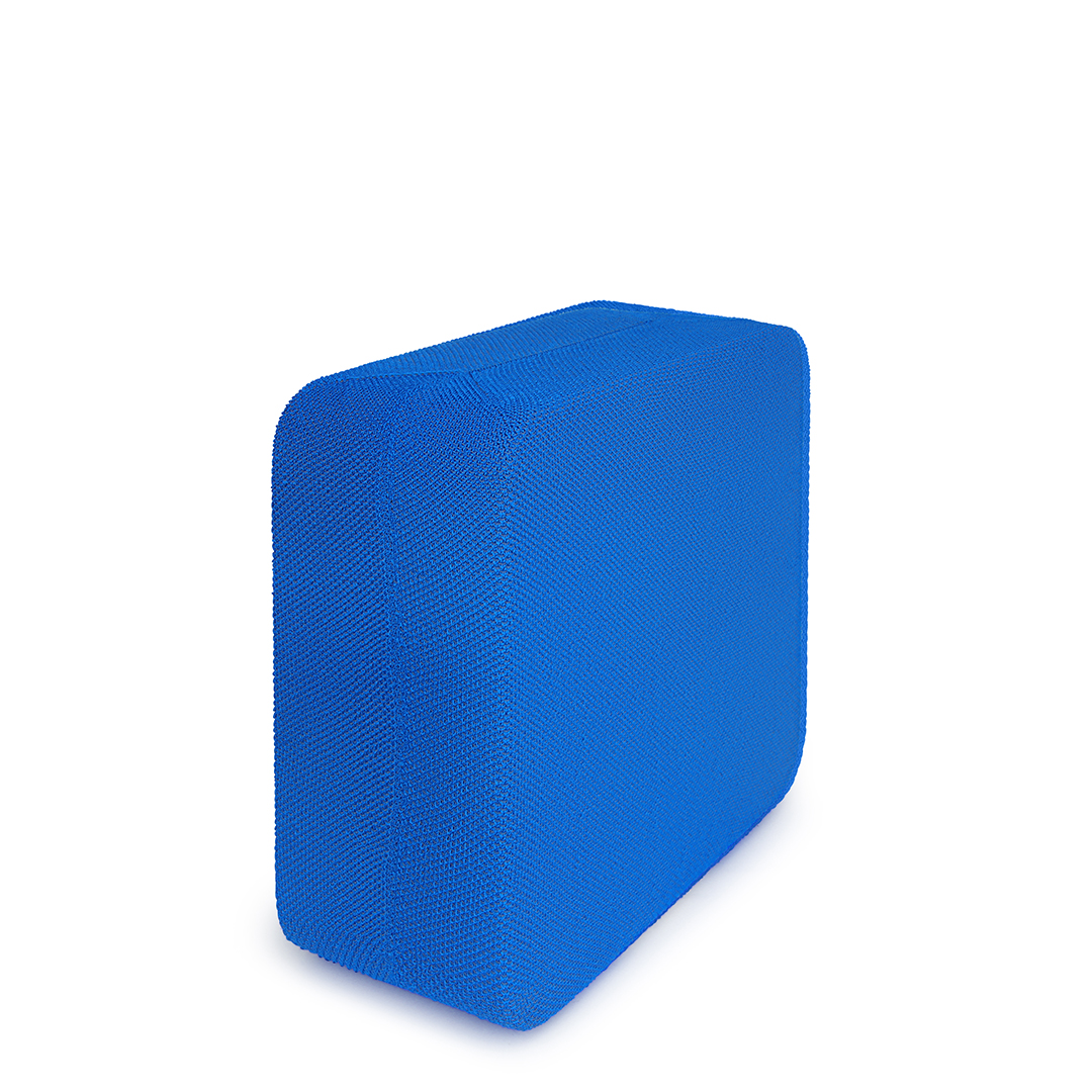 Un objet bleu, rectangulaire, recouvert de tissu sur fond blanc, avec des ombres.