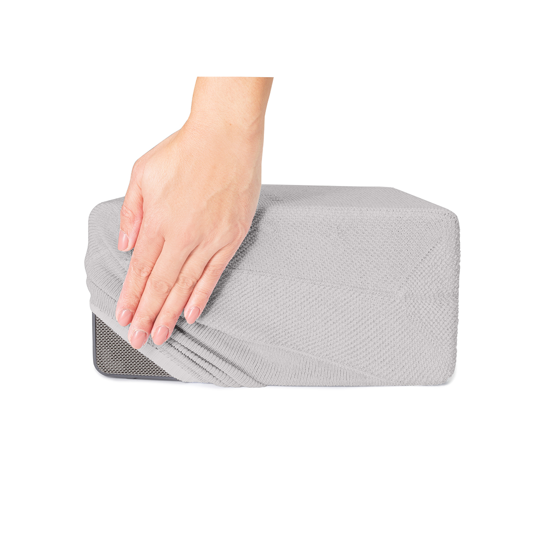 Une main recouvre un haut-parleur. Le haut-parleur est gris et a un fond blanc.