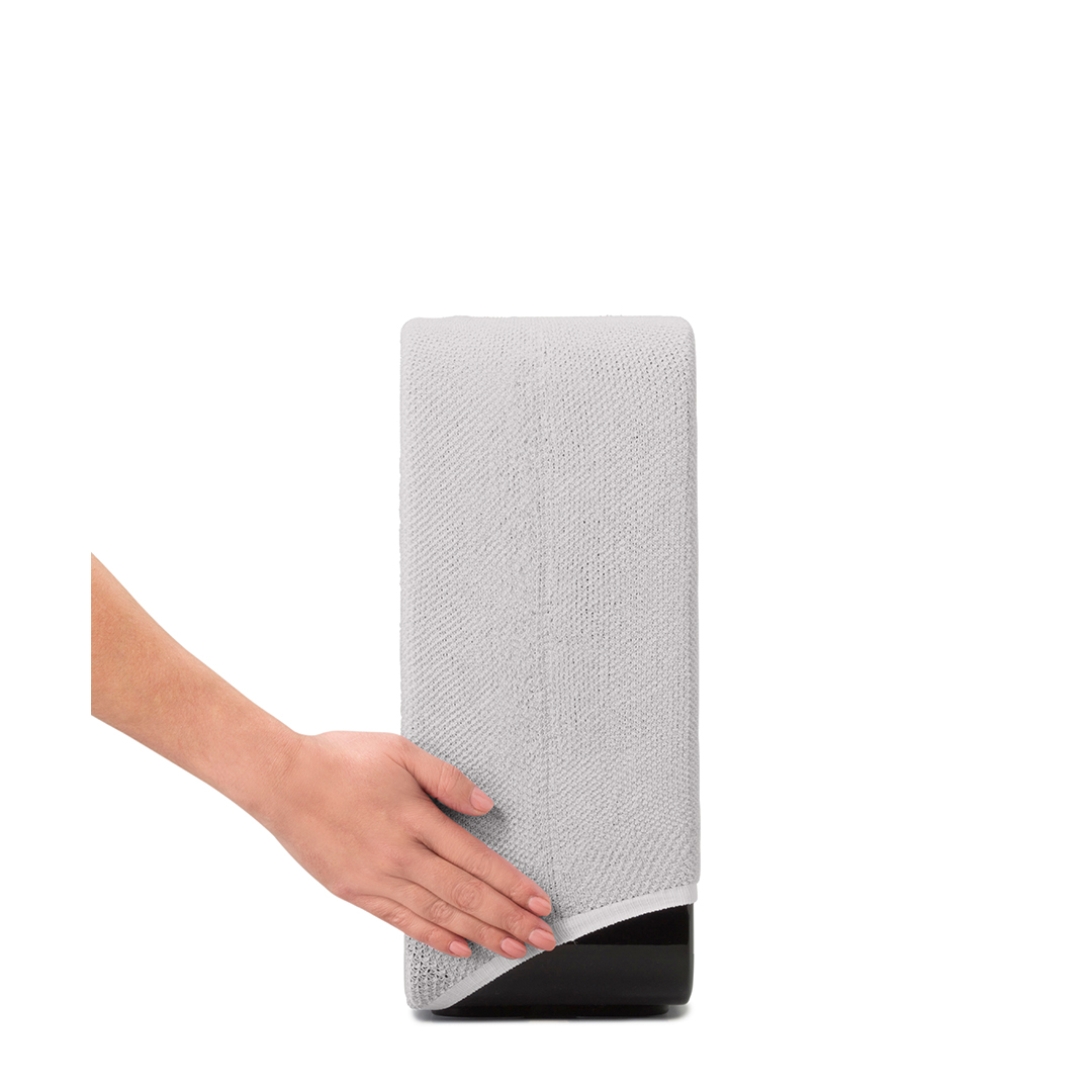Une main tenant une serviette en microfibre gris clair sur un support noir sur fond blanc.
