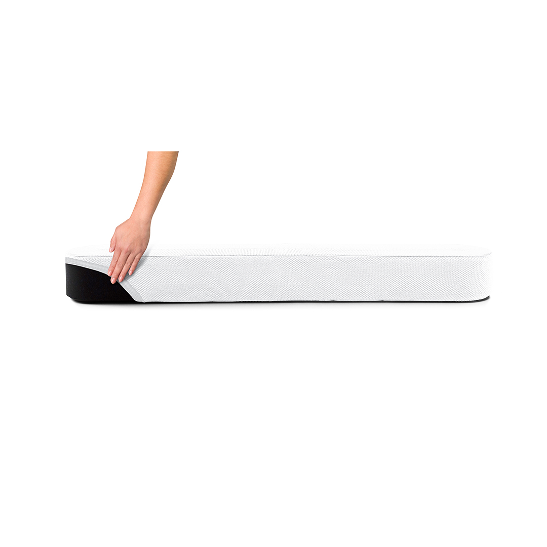 Une main touchant un matelas blanc avec une bordure noire.