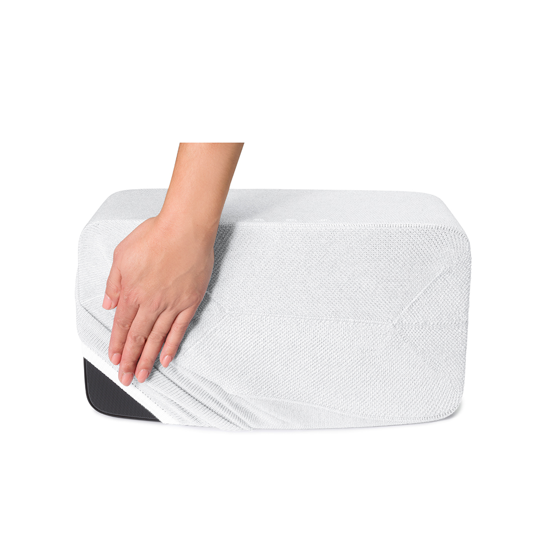 Une main tire un tissu blanc sur un rectangle blanc. Il est sur un fond blanc.