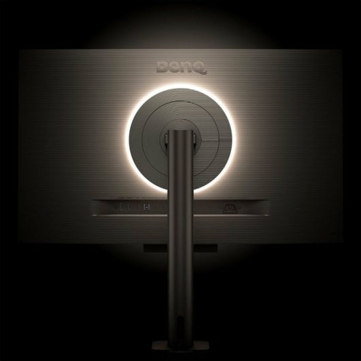 Tył monitora z świecącym okręgiem i logo BENQ, na czarnym tle.