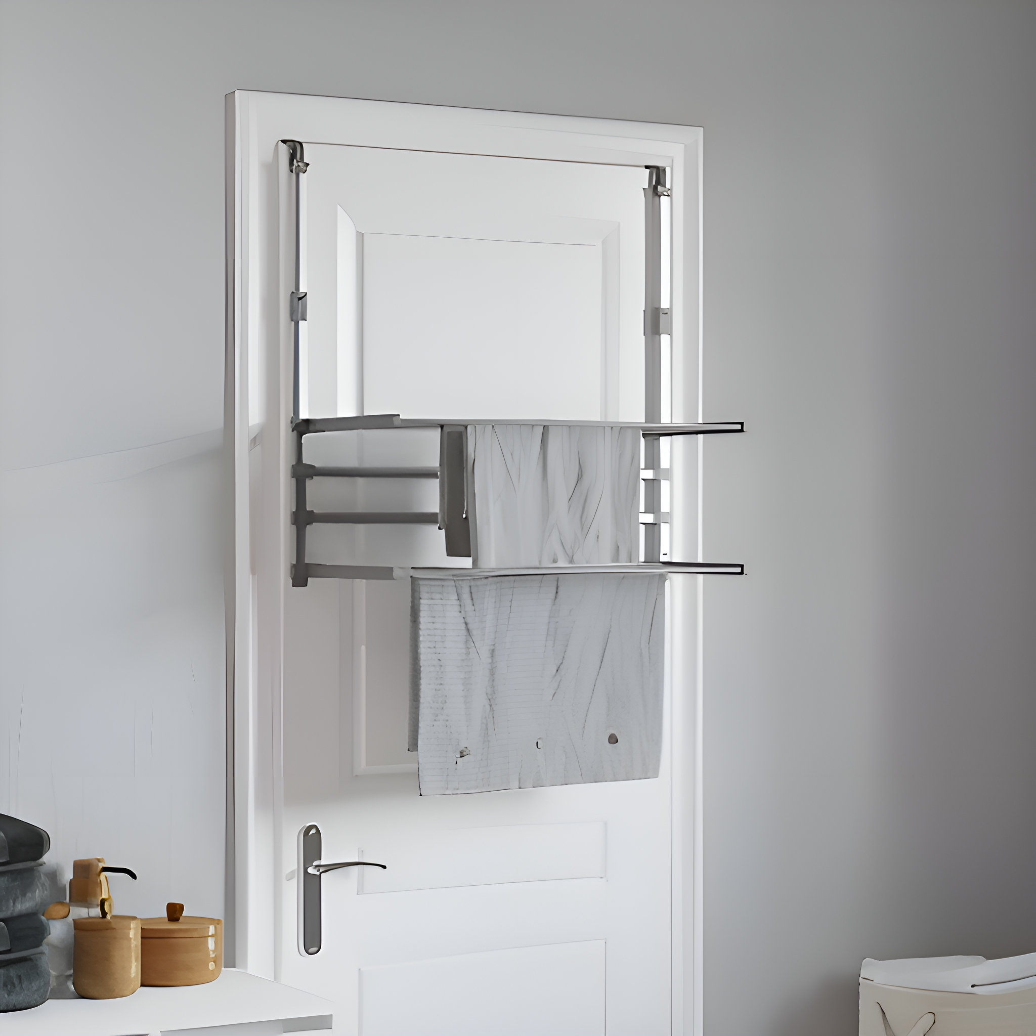 Handtuchhalter an einer Tür. Graue Handtücher. Weiße Tür und Wand.
