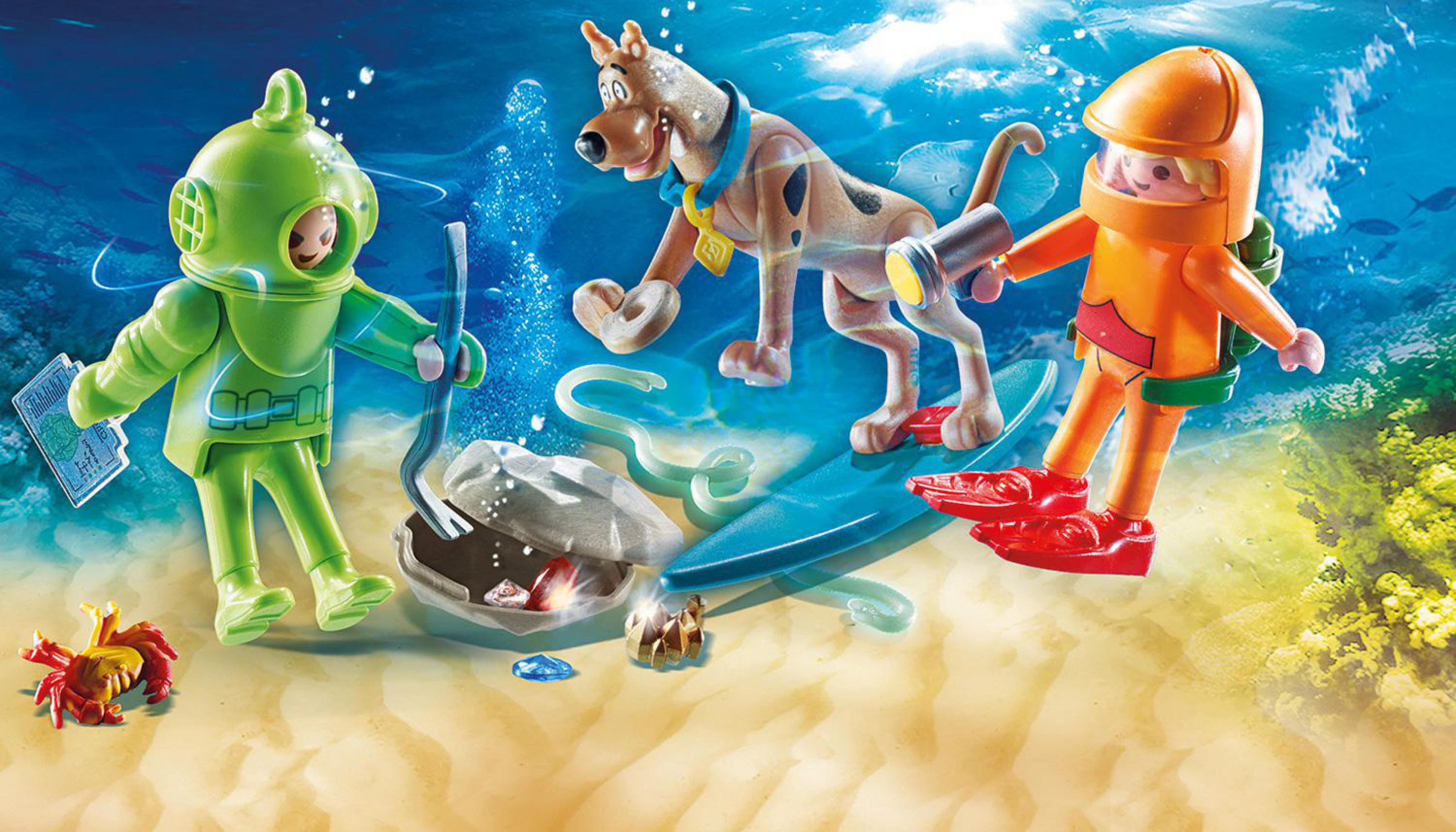 Scooby-Doo und Taucher im Ozean. Taucher links, Scooby in der Mitte, anderer Taucher auf einem Brett. Unterwasserszene.
