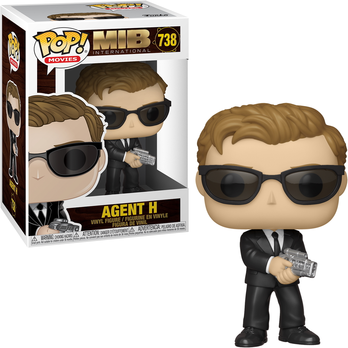 Agent H Figur aus dem Film MIB in der Box. Er trägt einen schwarzen Anzug, eine Sonnenbrille und hält eine Waffe.