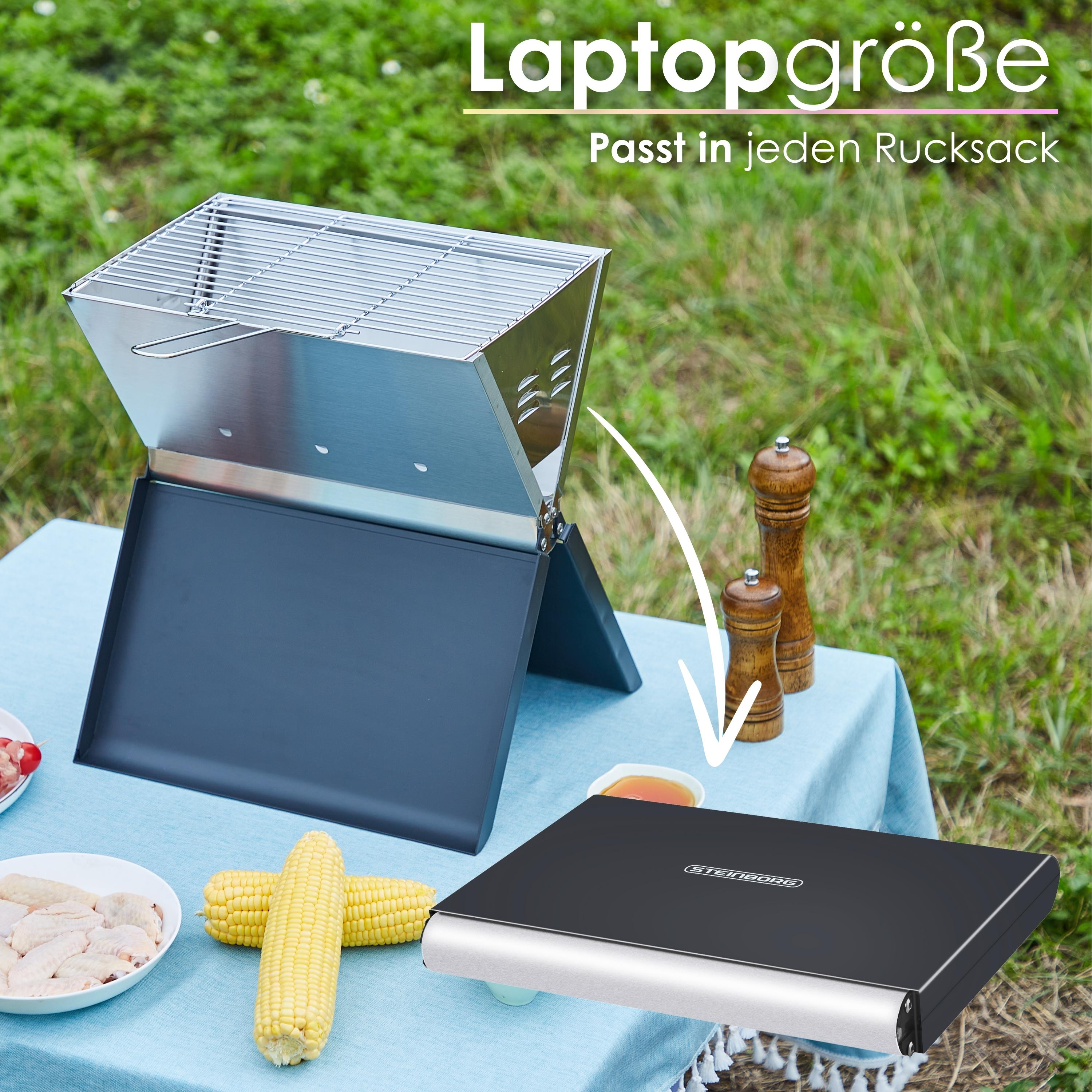 Ein tragbarer Grill auf einer blauen Tischdecke. Enthält Maiskolben und Hähnchenflügel. Laptop-Größe.