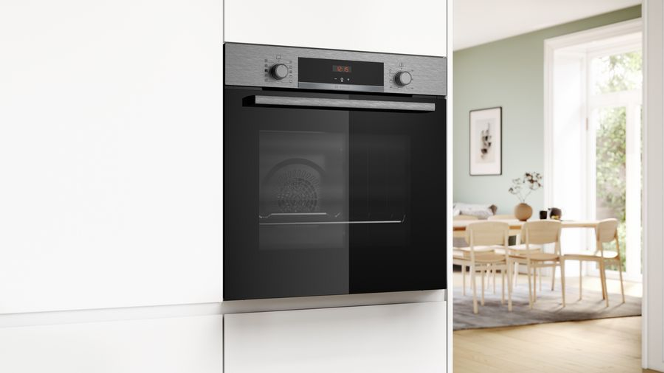 L'immagine mostra un forno a incasso con display digitale, incassato in un mobile da cucina bianco, in una cucina moderna.