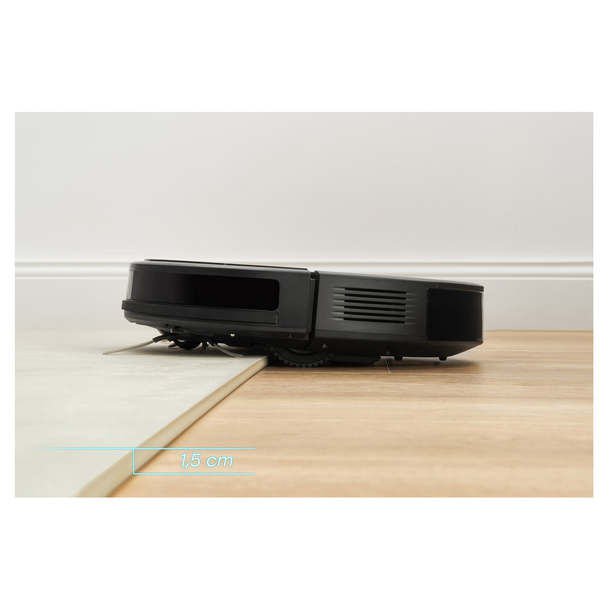 A black robot vacuum cleaner on a wooden floor, with a white tile in front. Distance: 1.5cm.