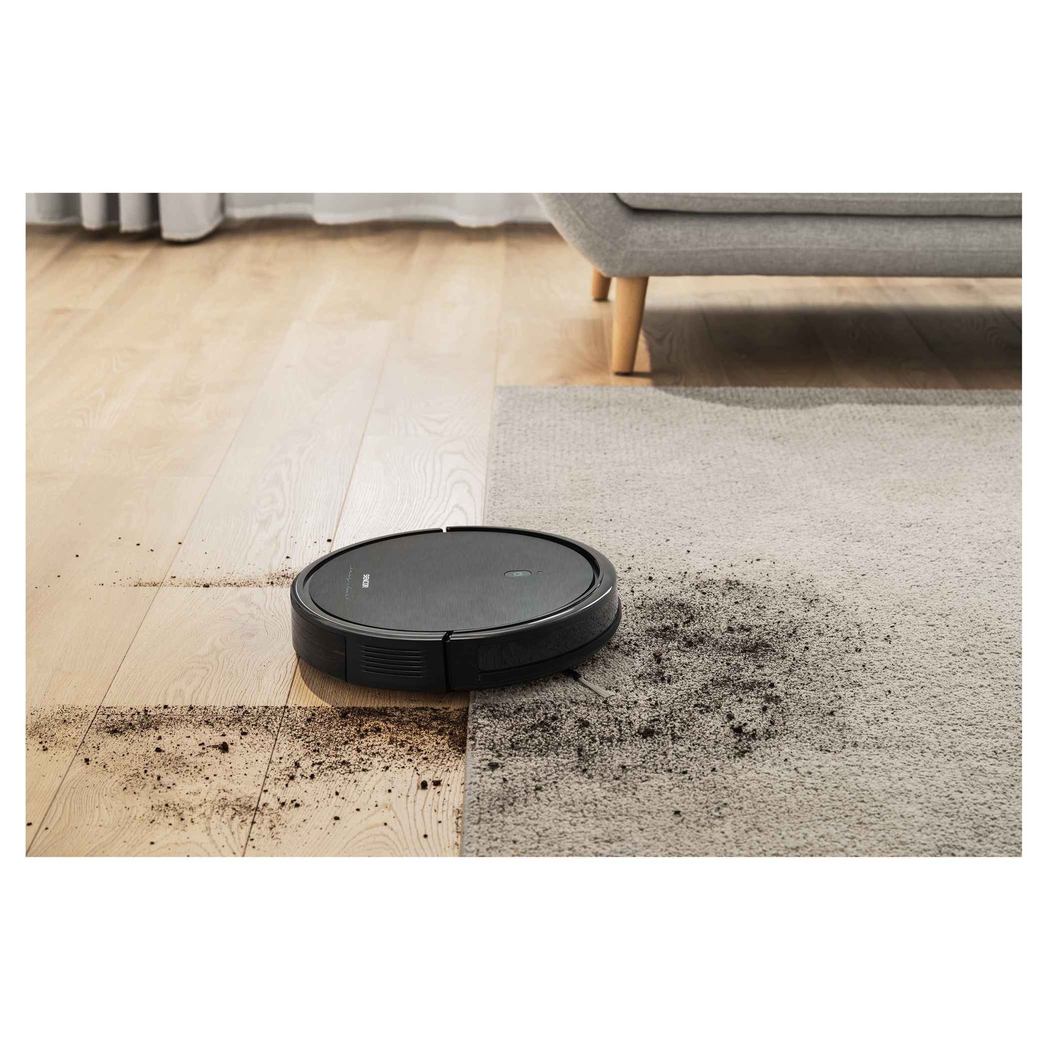 Robot vacuum cleaner on a hardwood floor and carpet. It shows the cleaning path and collected debris.