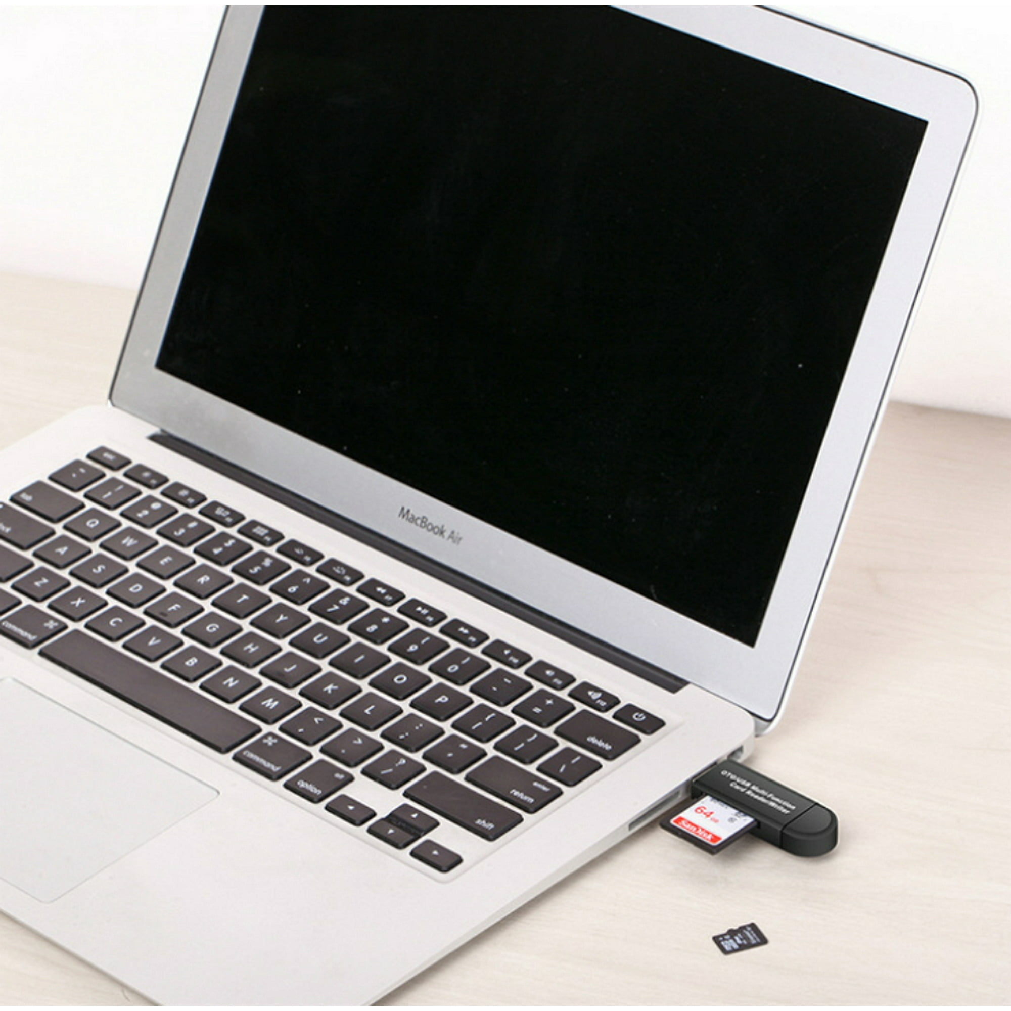 Ein Laptop mit einem eingesetzten USB-Laufwerk. Eine kleinere SD-Karte liegt neben dem Laptop.