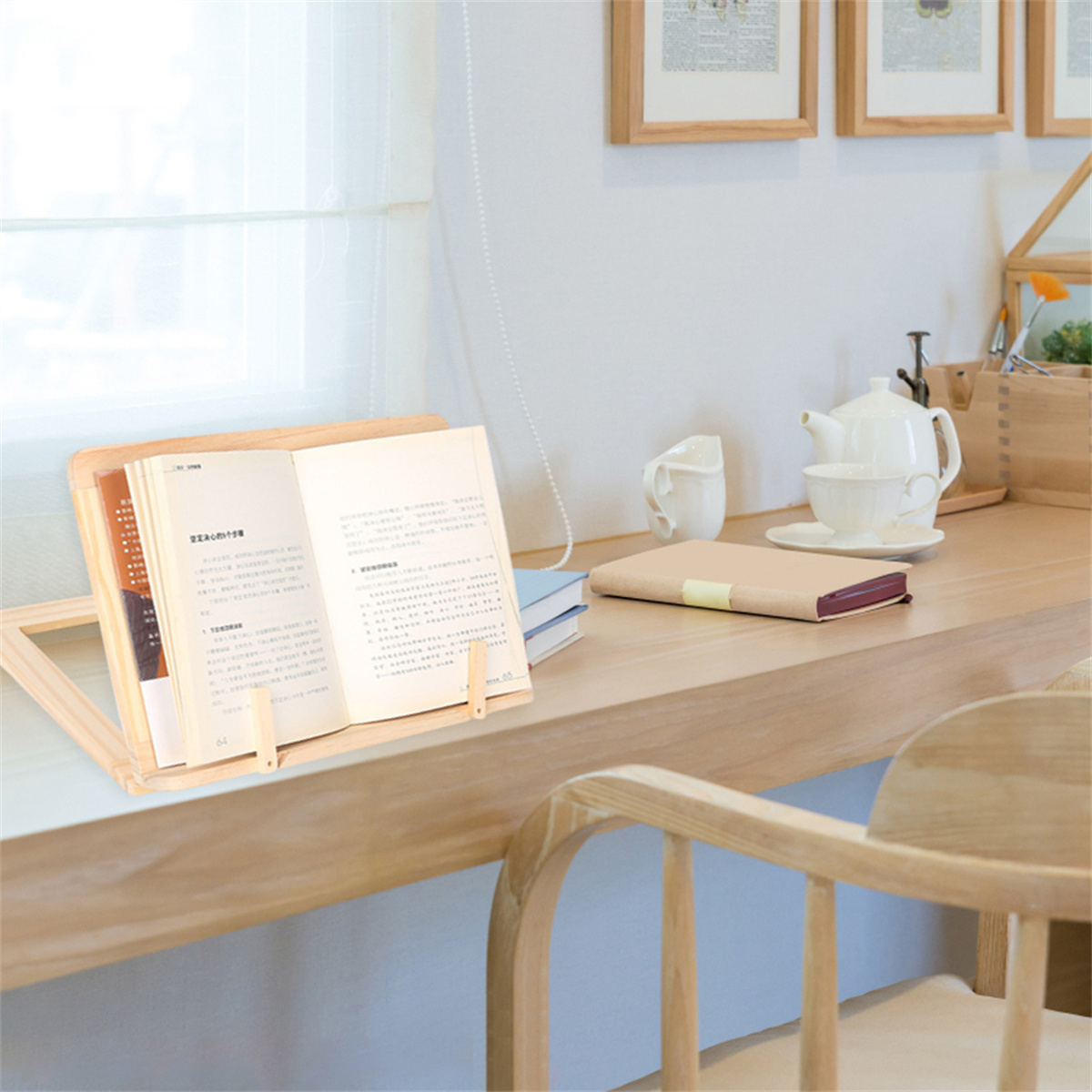 Ein hölzerner Buchständer mit einem geöffneten Buch. Eine Teekanne und eine Tasse stehen im Hintergrund.