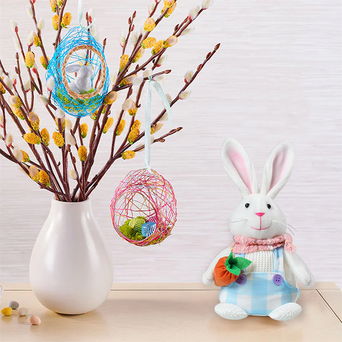Osterszene mit Hase, Eiern in Nestern auf Zweigen in einer Vase. Weißer Hintergrund.