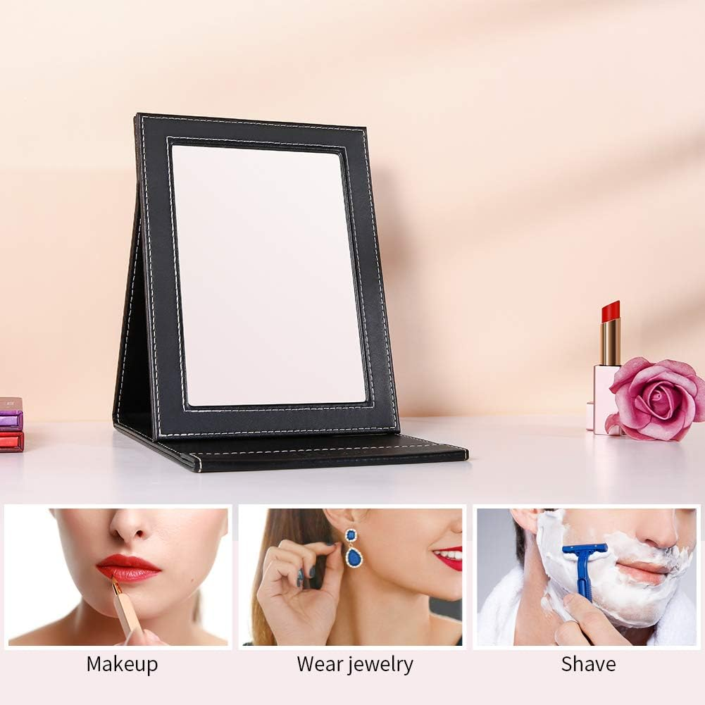 Ein schwarzer Fotorahmen Spiegel ist offen, zeigt Lippenstift, eine Rose und drei Bilder von Make-up, Schmuck und Rasur.