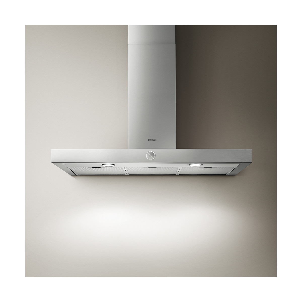 Cappa in acciaio inox su muro beige chiaro e marrone. Logo Elica visibile.