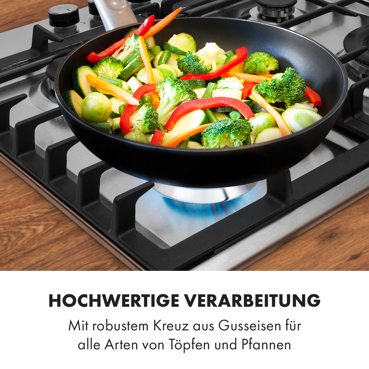 Eine Bratpfanne mit Gemüse auf einem Herd. Der Herd ist aus Edelstahl, und der Brenner ist angezündet.