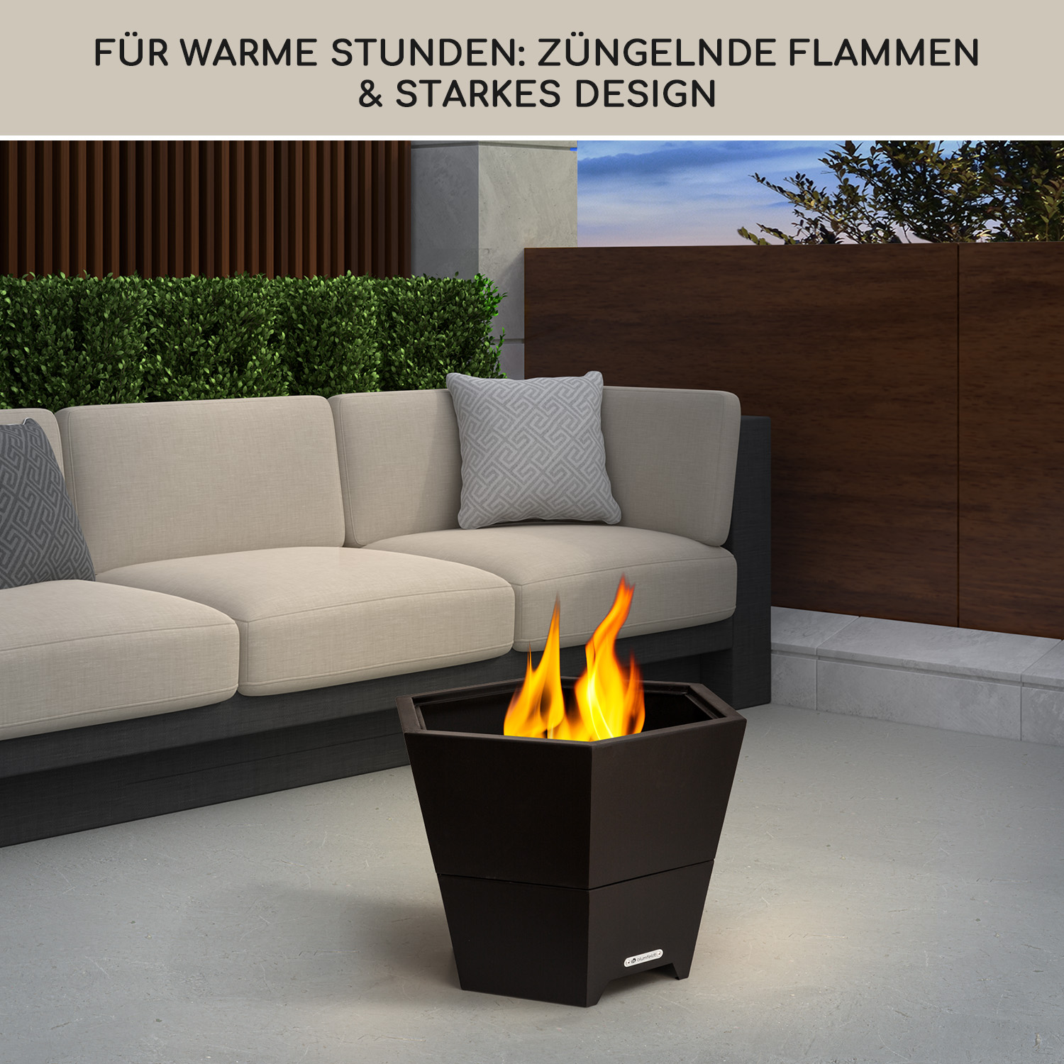 Feuerstelle mit Flammen auf einer Terrasse mit Sofa und Pflanzen.