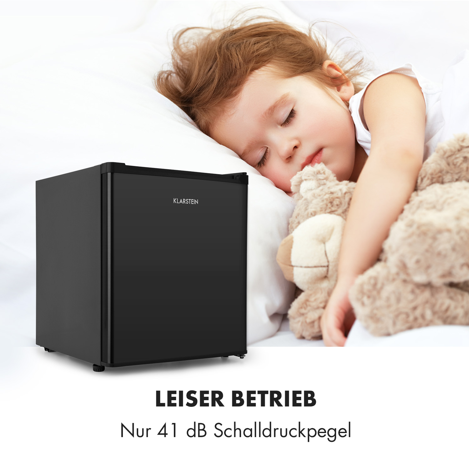 Niña durmiendo cerca de una mini-nevera negra. El texto dice 'LEISER BETRIEB'.