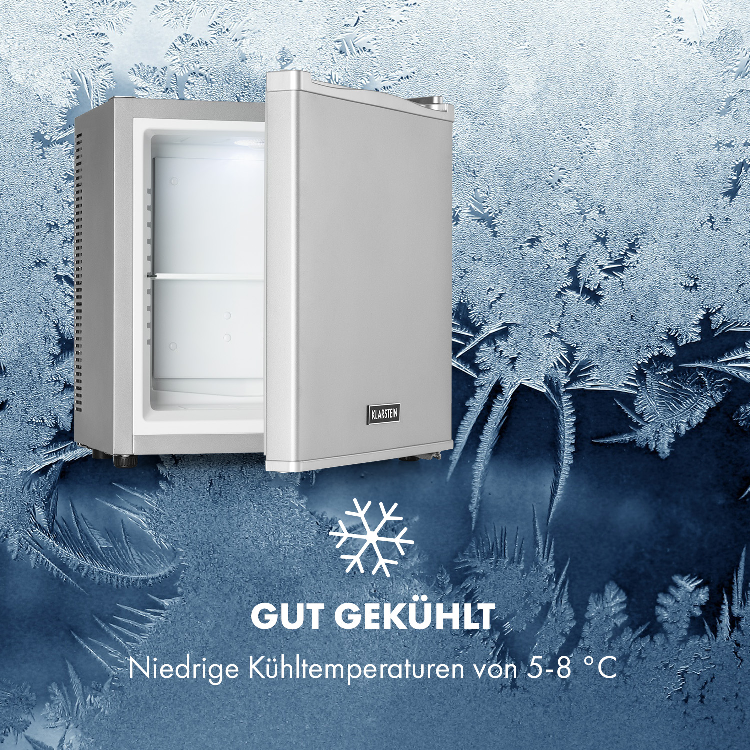 Ein silberner Mini-Kühlschrank mit offener Tür, vor gefrostetem blauem Hintergrund, mit Text.