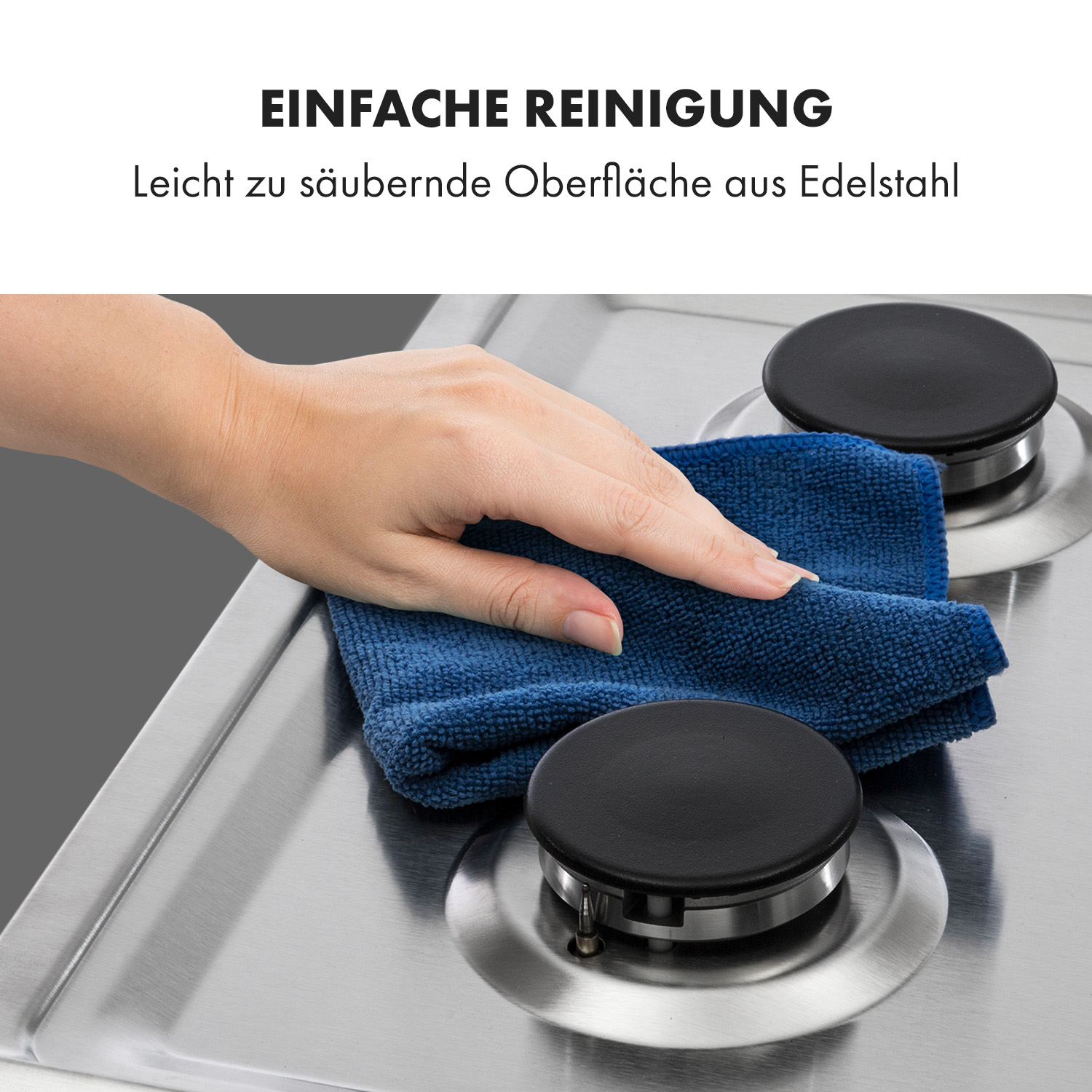 Eine Hand wischt mit einem blauen Tuch über eine Edelstahlkochfeld mit zwei schwarzen Brennern.