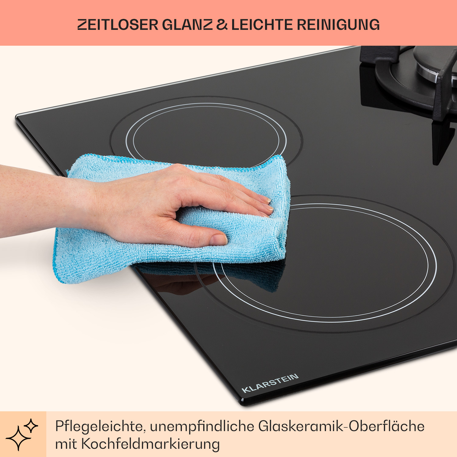 Una persona pulisce un piano cottura in vetroceramica nero con un panno blu. Il piano cottura ha due cerchi.