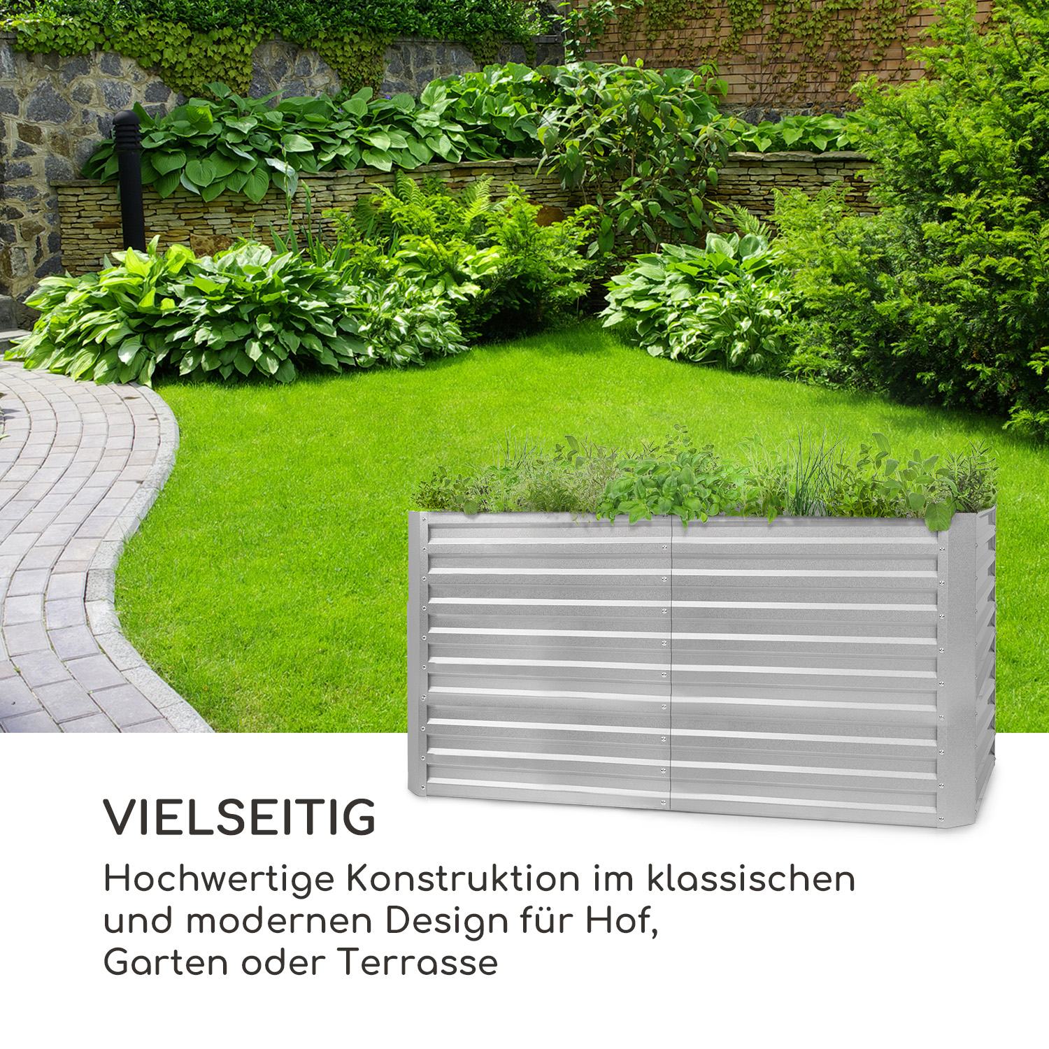 Ein erhöhtes Gartenbeet in einem üppig grünen Garten, begrenzt von einer Steinmauer und einem Weg.