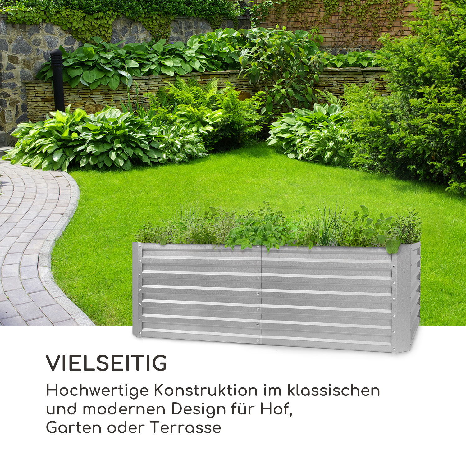 Erhöhtes Gartenbeet aus silbernem Metall mit Pflanzen. Grünes Gras und Steinmauer im Hintergrund.