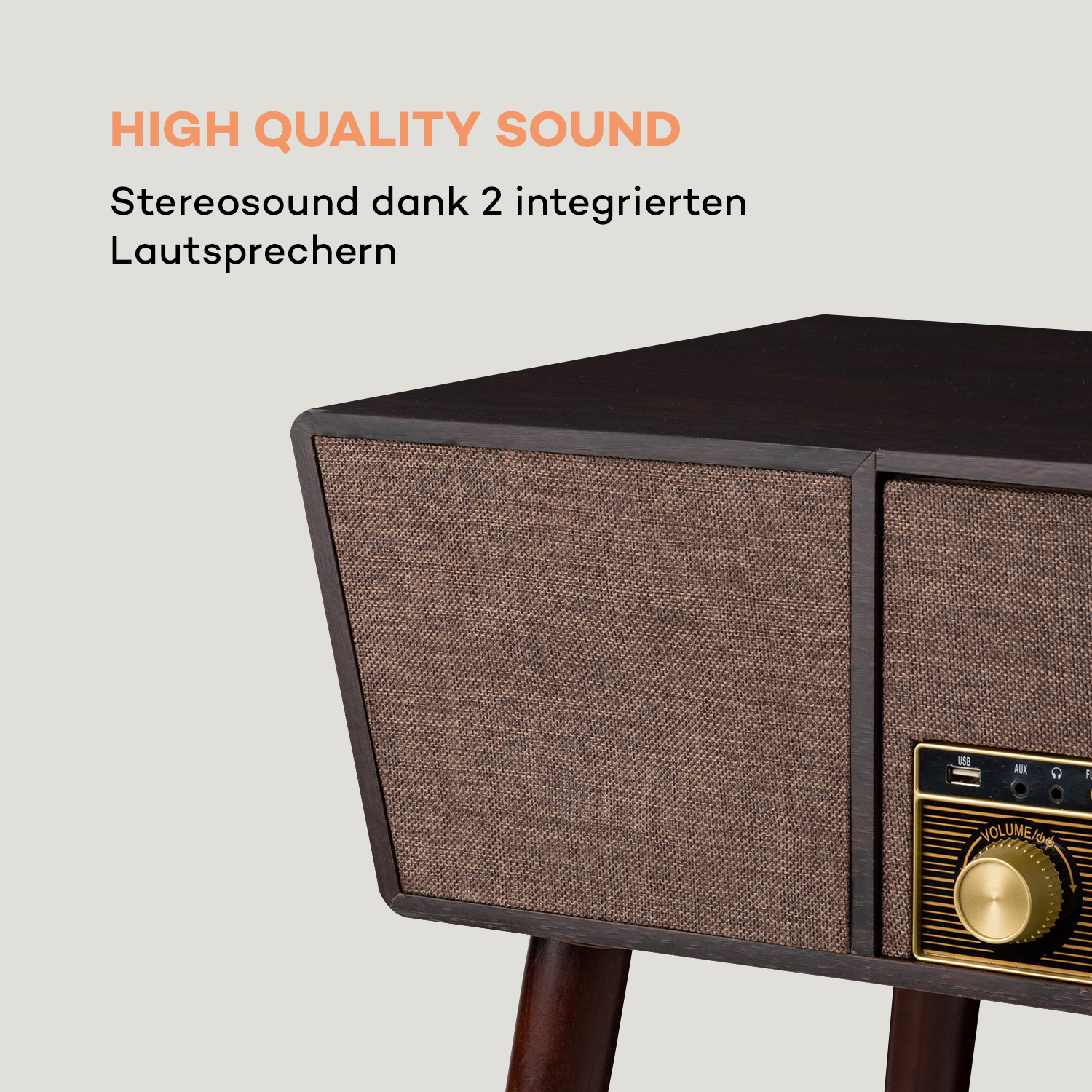 Primo piano di una radio in legno. Ha due altoparlanti rivestiti in tessuto marrone. Una manopola del volume e porte USB, AUX e altre.