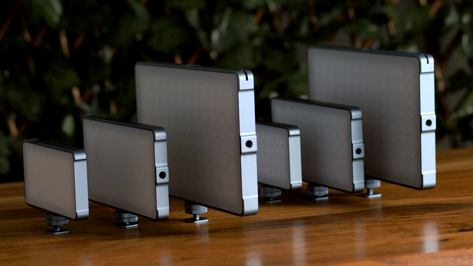 Six LED light panels of varying sizes arranged on a wooden surface. 